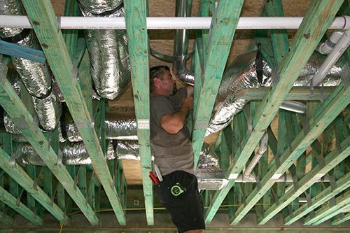 Service technician repairing commercial ductwork.